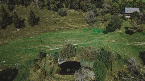 Aerial view of luxury mountain chalet with swimming pond in Austria