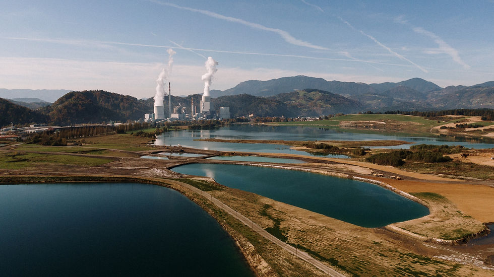 Geotermia superficial em área com reservatórios de água e edificações ao fundo, representando o uso da temperatura do solo para climatização sustentável em ambientes urbanos e industriais.