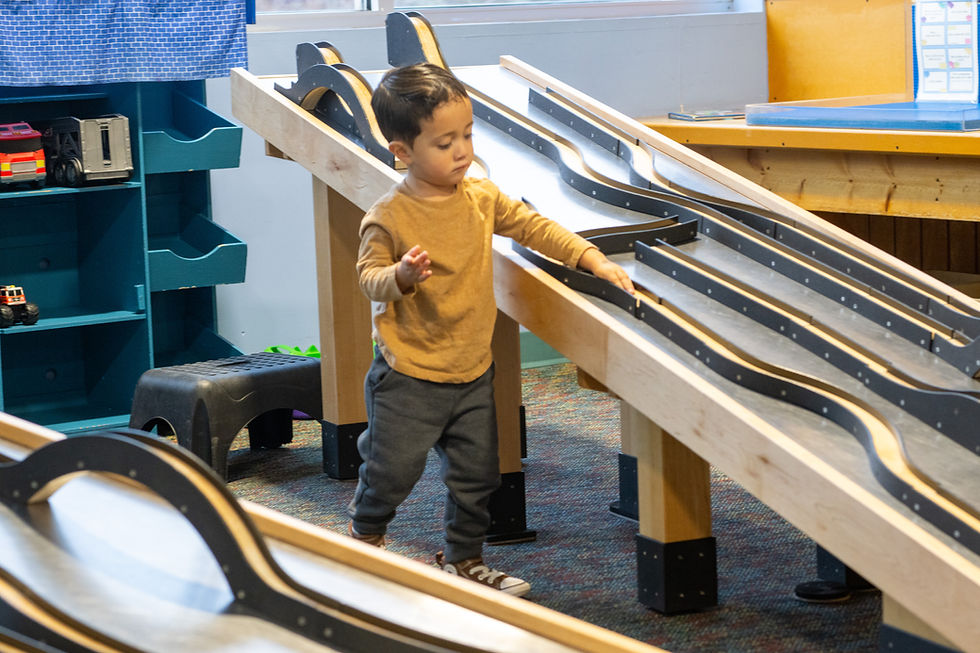 little boy playing at museum on the race track