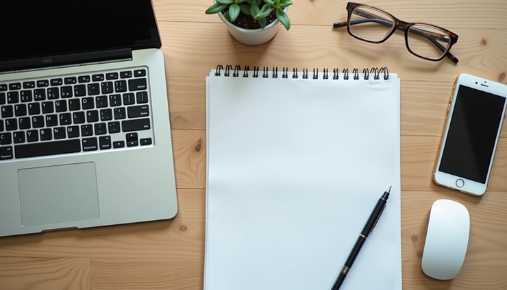 Vue en plongée d'un bureau avec un ordinateur portable et des notes organisées