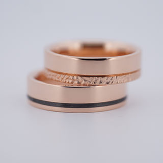 Zelta laulību gredzeni ar karbonu un deguma faktūru.