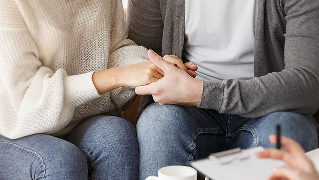 Reconciliation. Smiling Multiethnic Spouses Holding Hands Reconciling After Quarrel Sittin