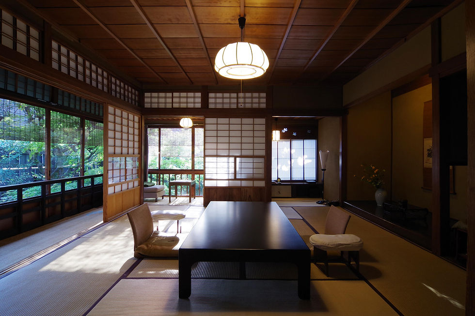 Traditional Japanese room with tatami mats and shoji screens. Low wooden table and cushions, warm lighting, peaceful ambiance.