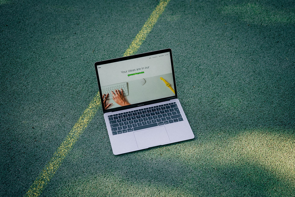 Laptop na zielonej bieżni z żółtą linią; na ekranie strona z napisem Your ideas are in our good hands.