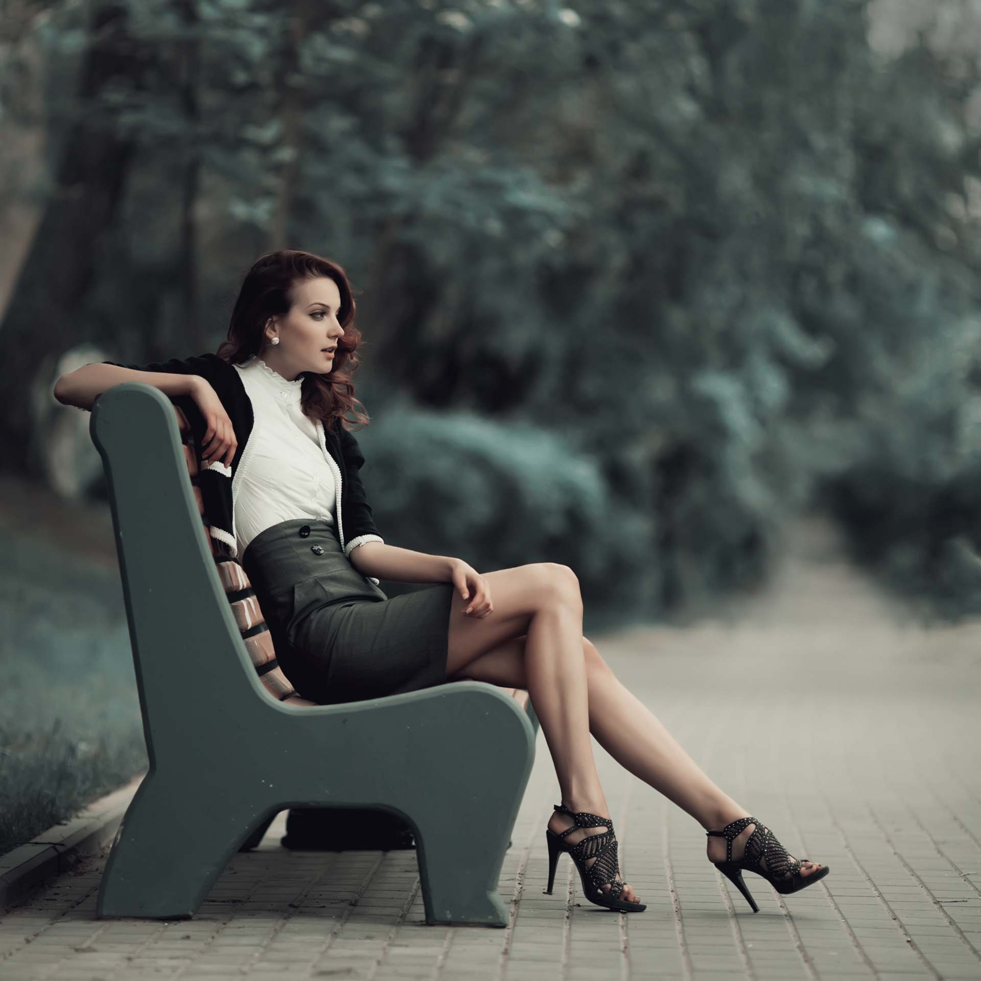 Woman wearing stilettos sitting on a bench