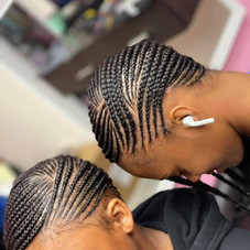 This is an alt text of a client with small braids lying close to the scalp in clear sections.