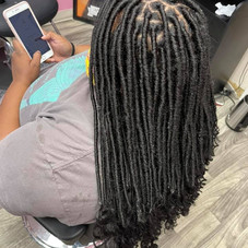 This is an alt text of a client with a long knotless twists hairstyle that reaches their mid back.