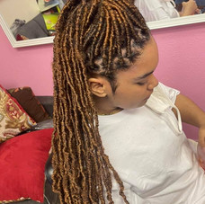 This is an alt text of light brown microbraids pulled up into a high ponytail.
