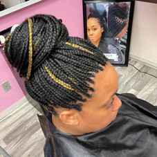 This is an alt text of a dark braided updo with three blonde braided streaks.