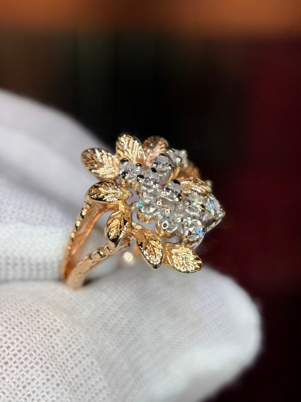 Thumbnail: Gold floral cluster ring with round diamonds on white fabric