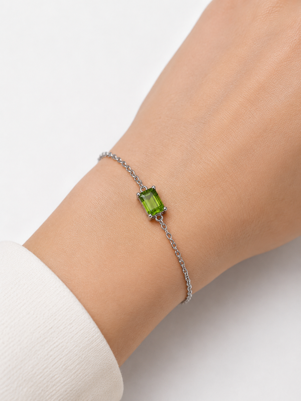 Thumbnail: Silver chain bracelet with emerald-cut green stone on wrist