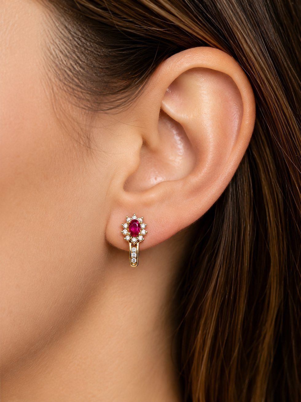 Ruby and diamond halo earring worn on a person's ear