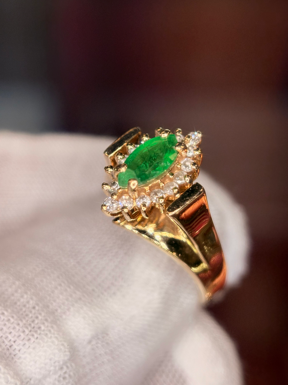 Thumbnail: Marquise-cut emerald and diamond cluster ring in gold.