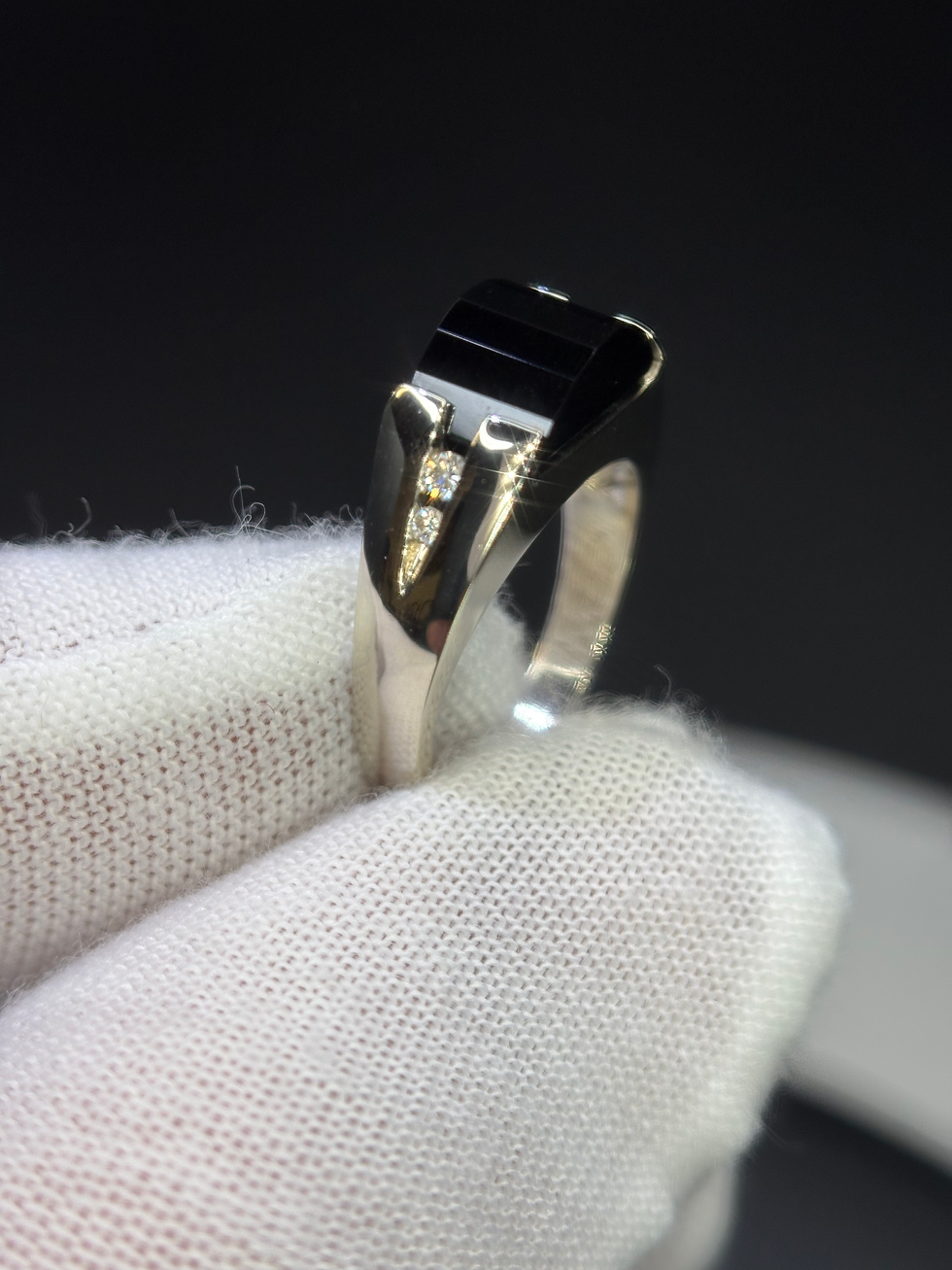 Thumbnail: Silver ring with black gemstone held in a gloved hand