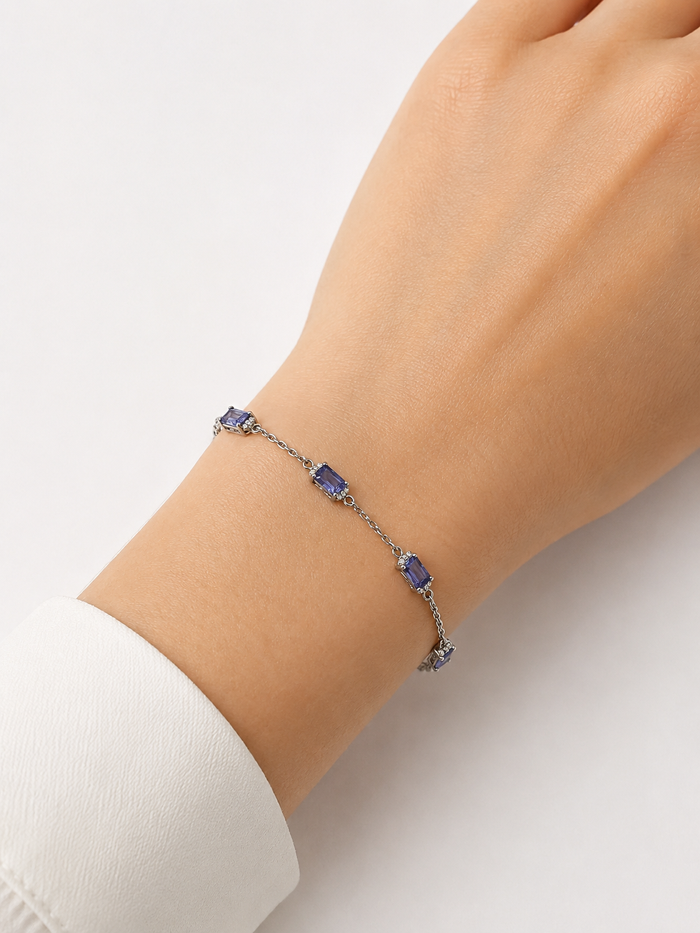 Thumbnail: Silver chain bracelet with blue gemstones on a wrist.