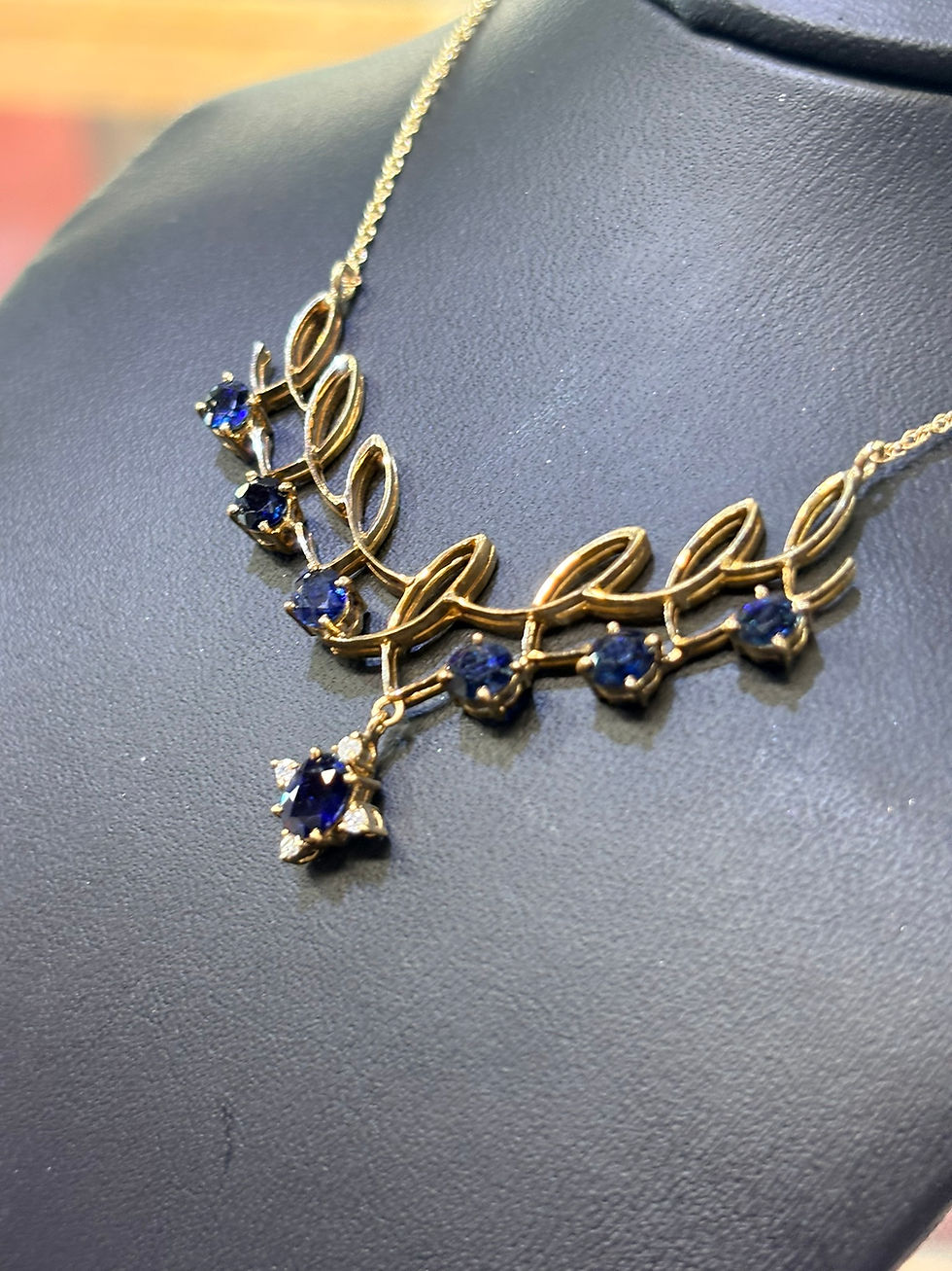 Thumbnail: Gold necklace with blue sapphires in a leaf pattern