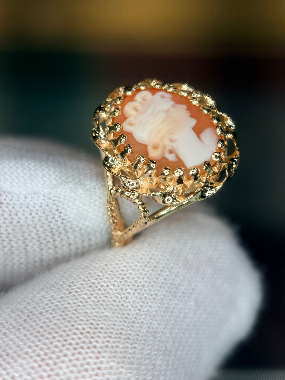 Thumbnail: Vintage cameo ring in gold being held by a gloved hand.