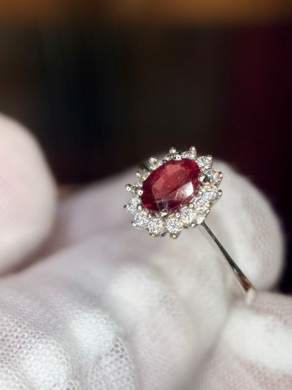 Oval ruby and diamond halo ring in white gold