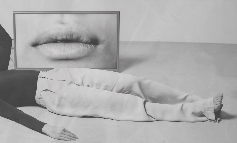 Une femme allongée devant un tableau d'une photographie qui représente une bouche