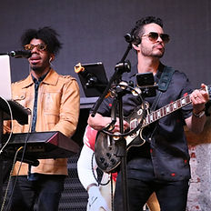 Dúo musical de Jimmy & The Benjamins interpretando en vivo: vocalista con micrófono y tecladista con laptop, ambientando un evento con energía y estilo.