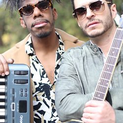 Dúo musical de Jimmy & The Benjamins posando con piano y guitarra