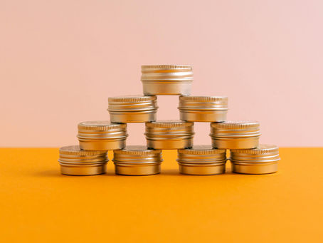 Pirâmide de caixas redondas douradas representando moedas empilhadas. Foto de Antoni Shkraba Studio.