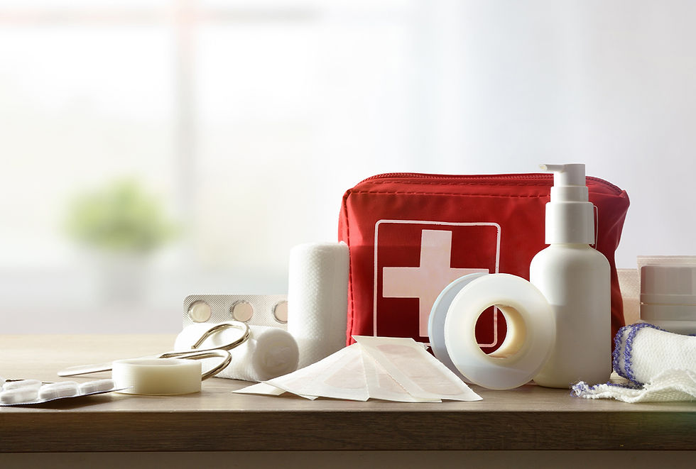 A first aid kit with some of the supplies scattered around it.