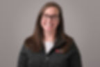 A smiling Dr. Sonya Hanson smiles, wearing glasses, a VEG jacket and white shirt.