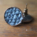Round, stud earrings with blue fabric design.