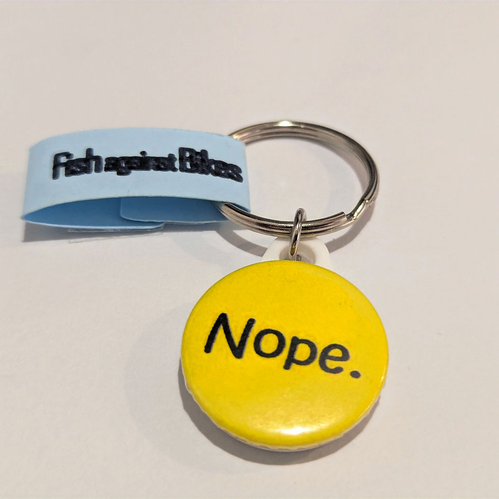 Keyring with black 'Nope.' slogan on yellow background.