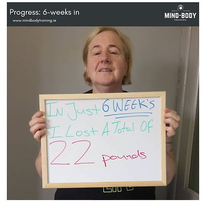 an image of Mag's displaying a sign celebrating the 22 lb weight loss she accomplished in her first 6 weeks with online personal training