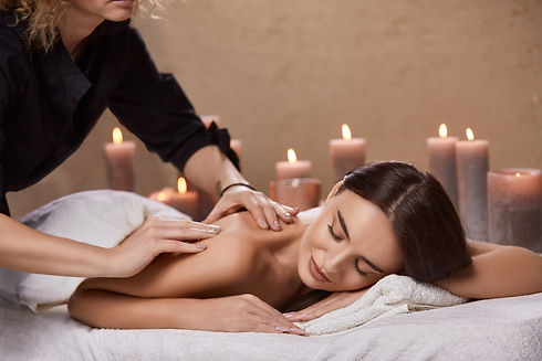 masseur-doing-massage-woman-s-back-spa-salon-with-many-candles.jpg