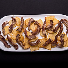 Lagartito ibérico sobre lecho de patatas fritas