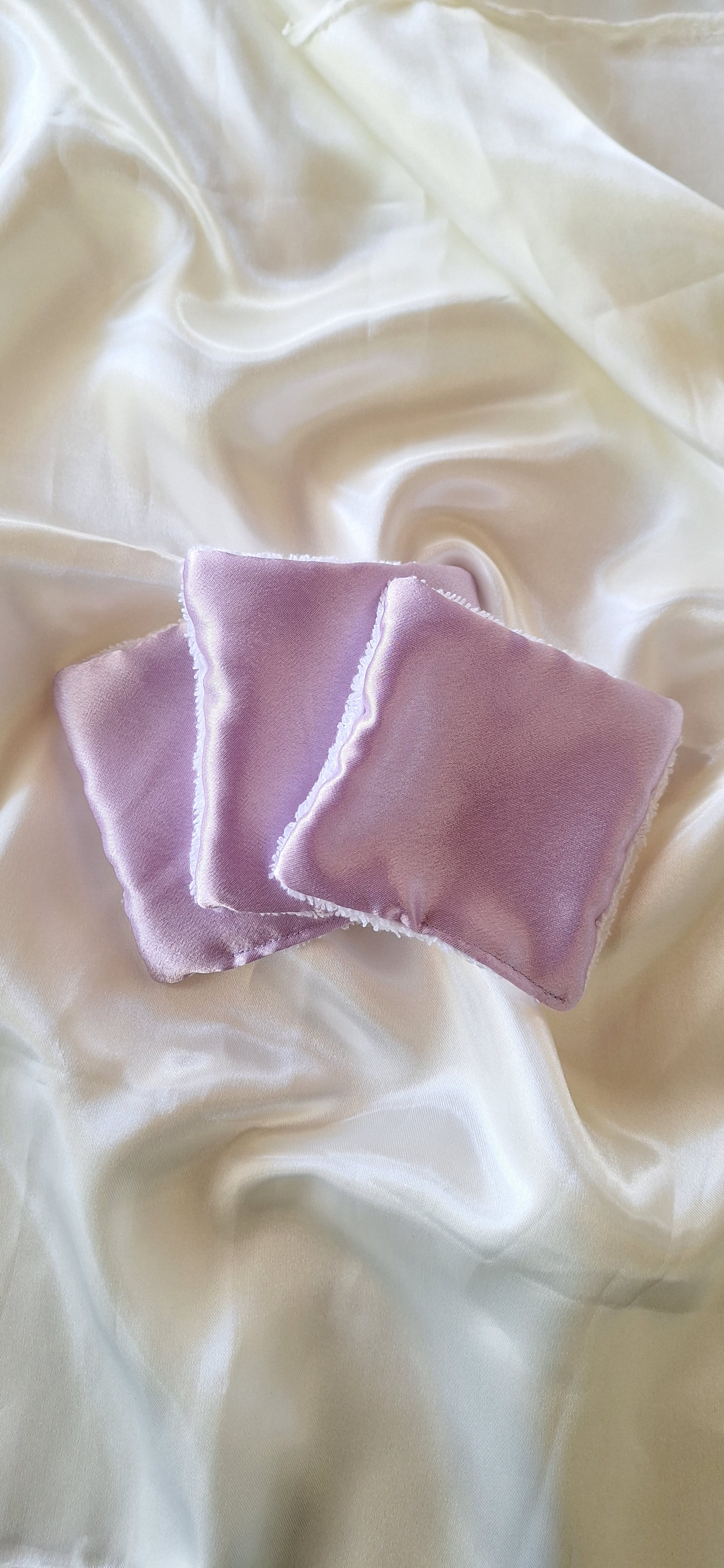 Trois lingettes violettes sur un tissu blanc, Imshé Sublime.