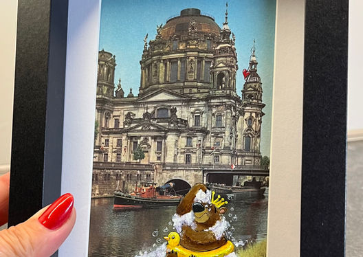 Bär mit Sonnenbrille im Gummiring vor Berliner Dom – humorvolle Kunstpostkarte von maleola
