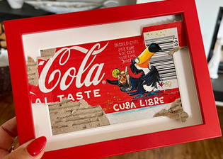 Gemaltes Bild auf einer Cola-Verpackung: Ein Tukan hält ein Glas Cuba Libre, daneben das Rezept. Das Ganze ist auf Wellpappe mit Barcode in einem roten Rahmen montiert.