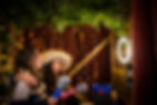 people laughing at their captured photos inside zoho photo booth surrounded with fairy lights qith photo booth props in their hands