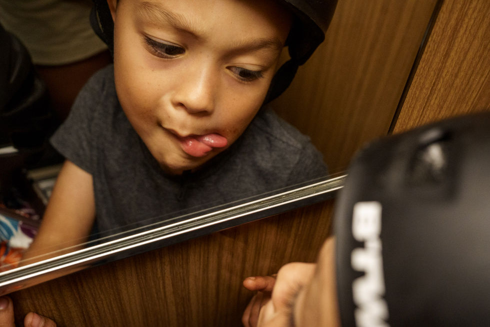 boy makes faces at the elevator mirror