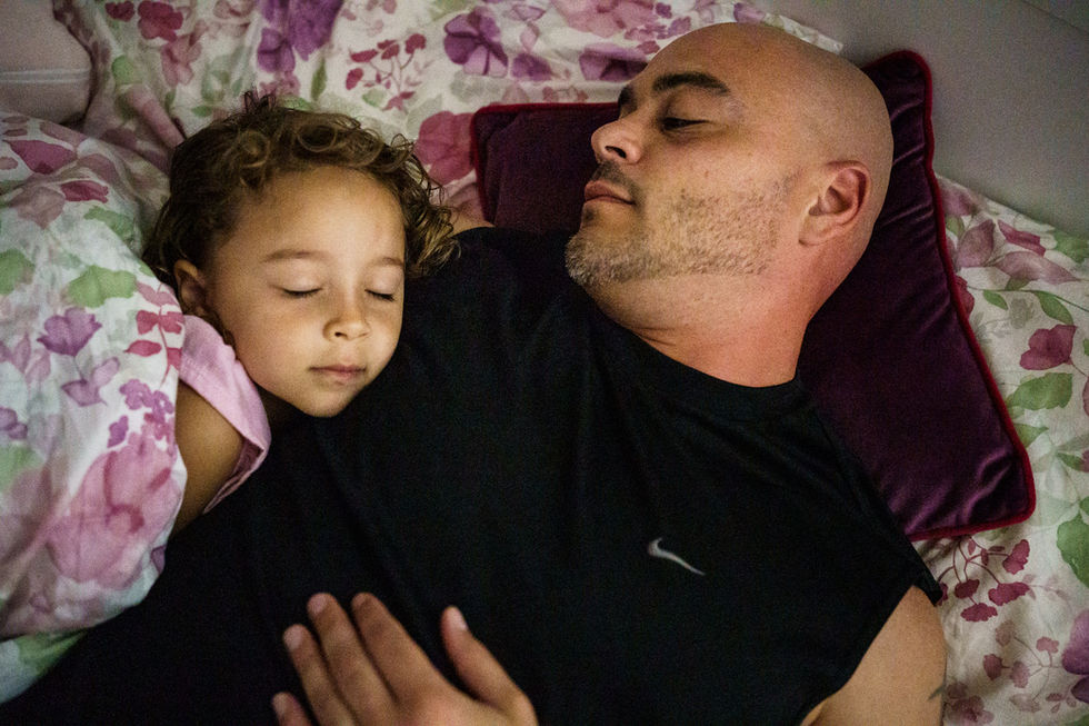 dad and daughter cuddle in her bed