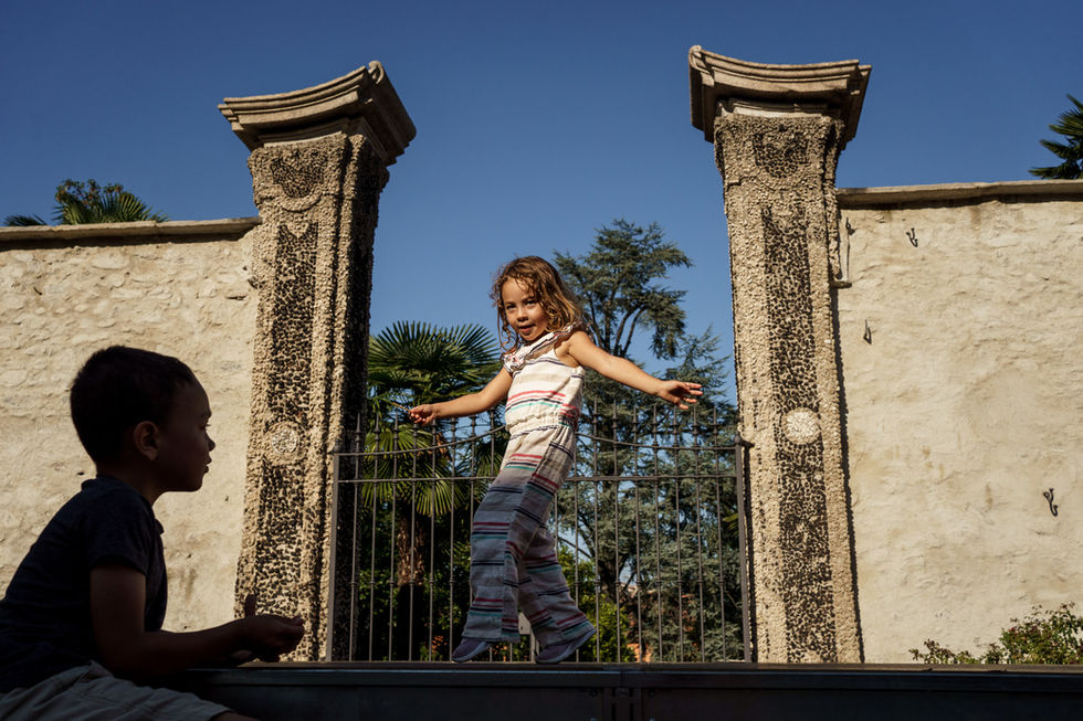brother watches his sister dance in the garden