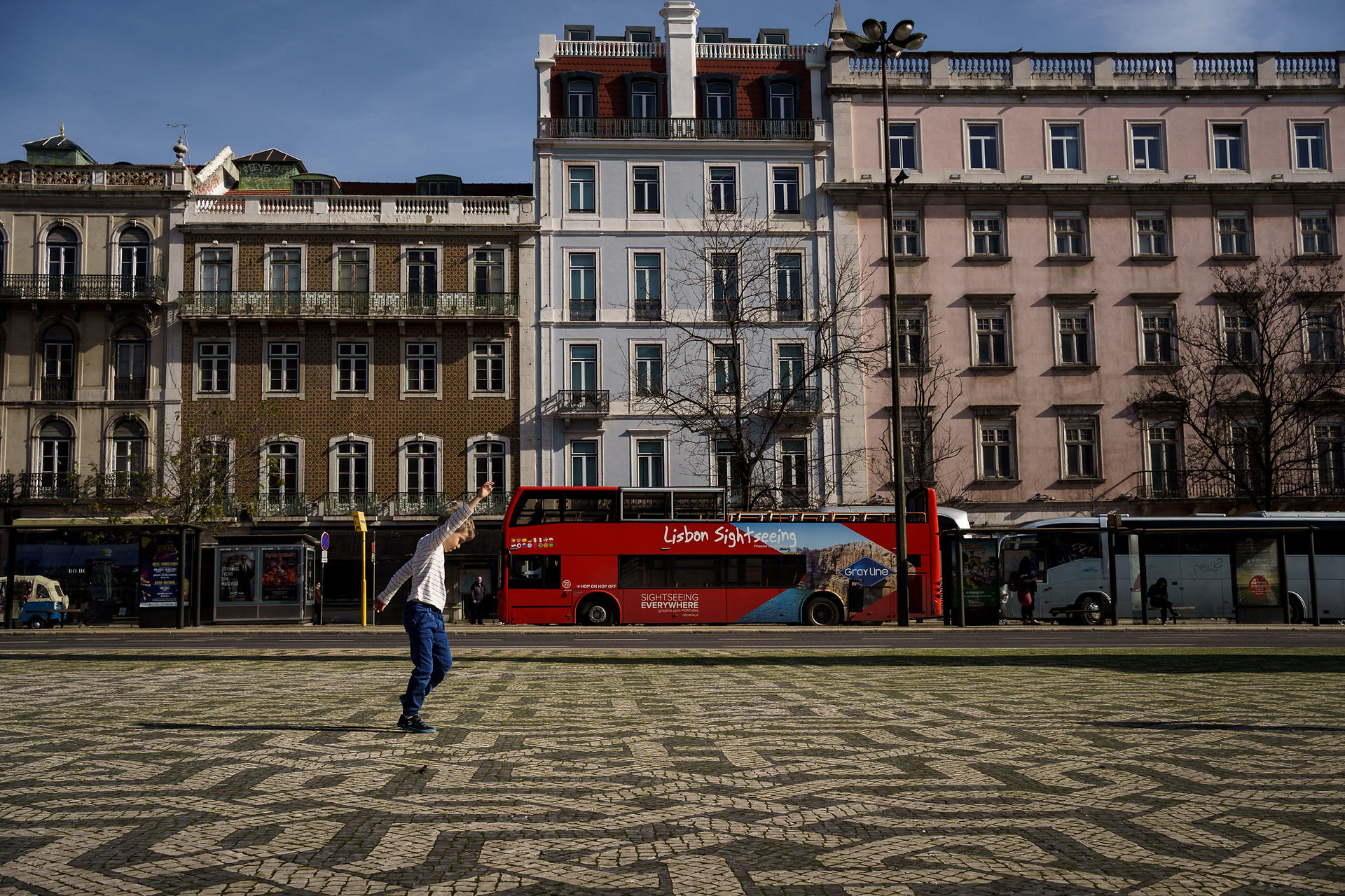 boy in lisbon and a sightseeing bus