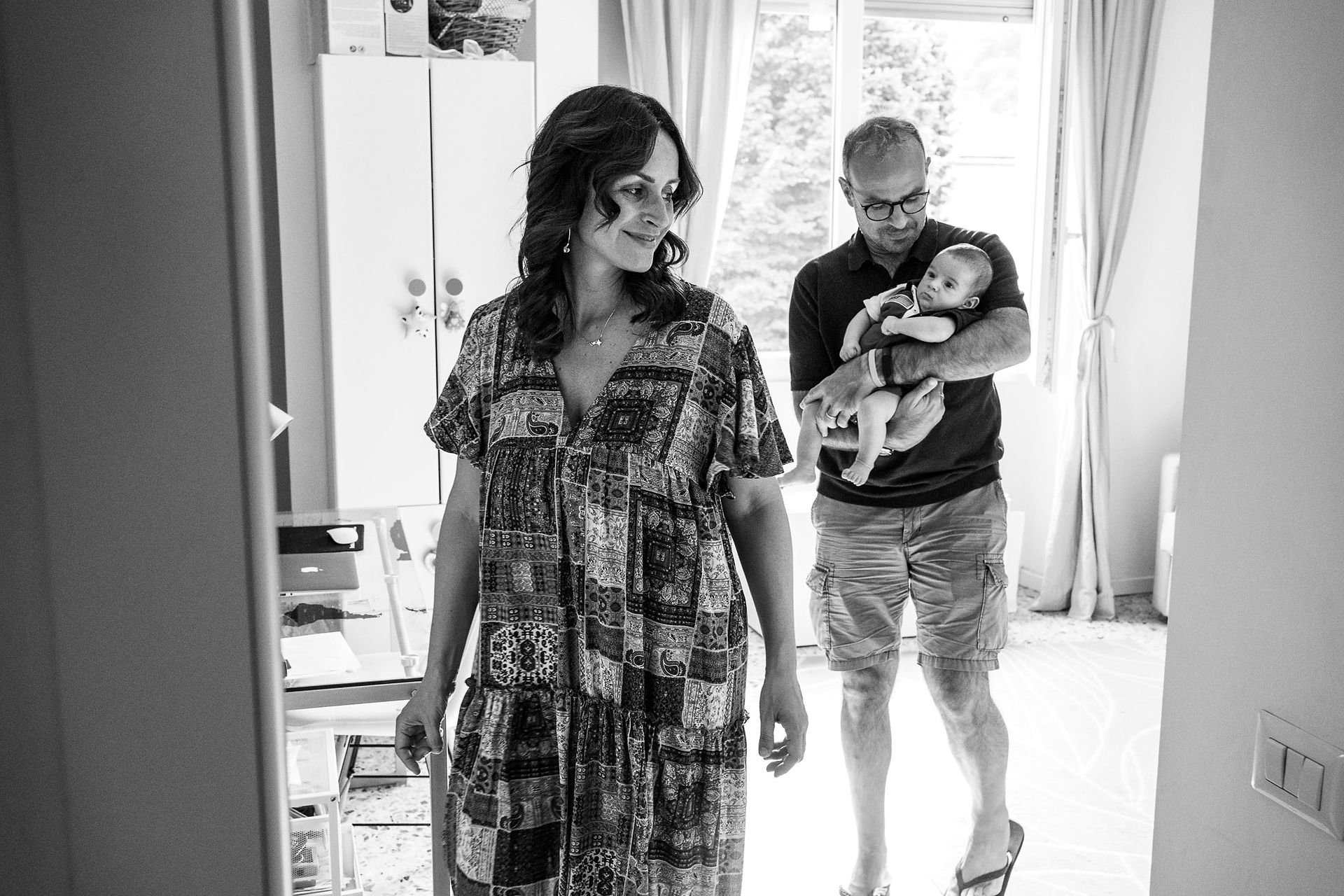 dad holds baby and follows mom out of nursery