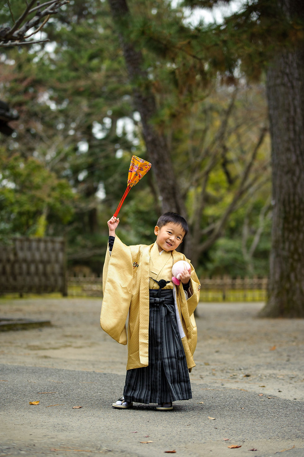 Cayden swings his bag while posing in his kimono with his stuffed animal