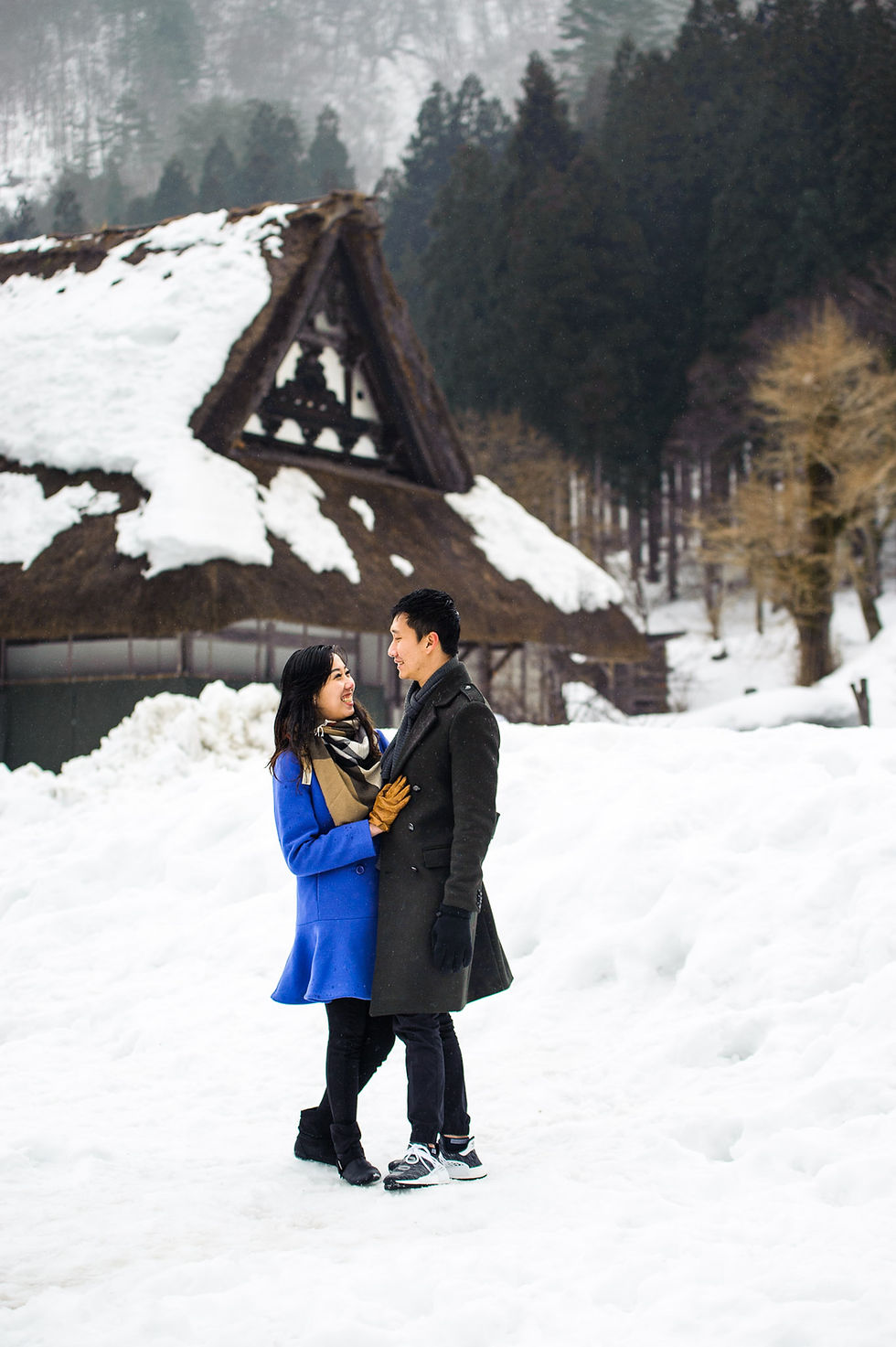 Mira and Sin in front of a snow covered house in Shirakawago