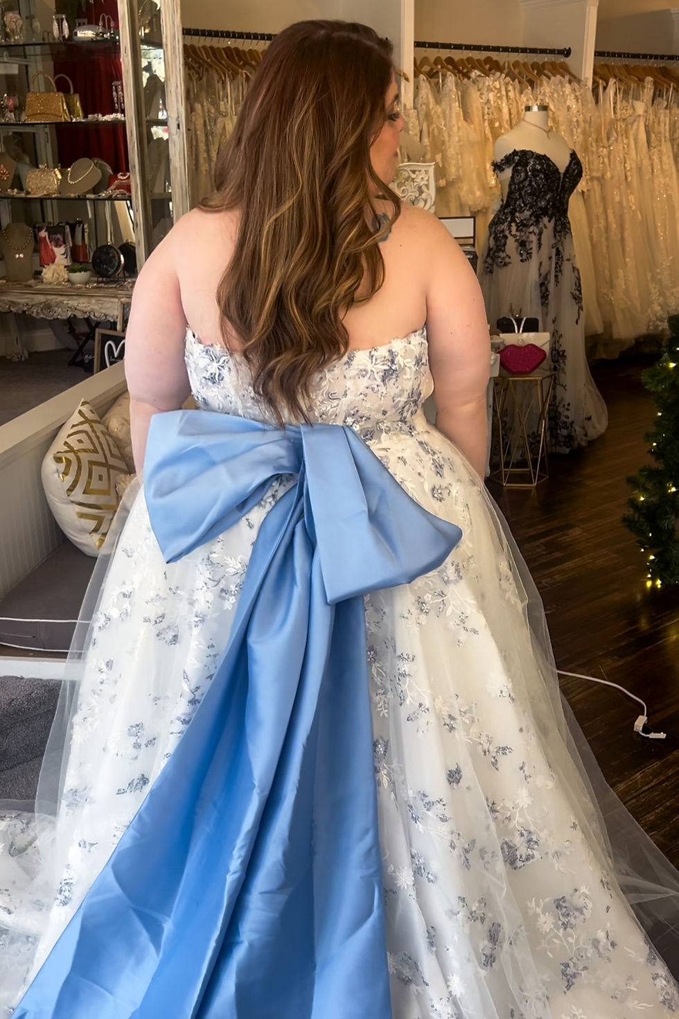 plus size woman wearing a white wedding dress with blue florals and a blue bow