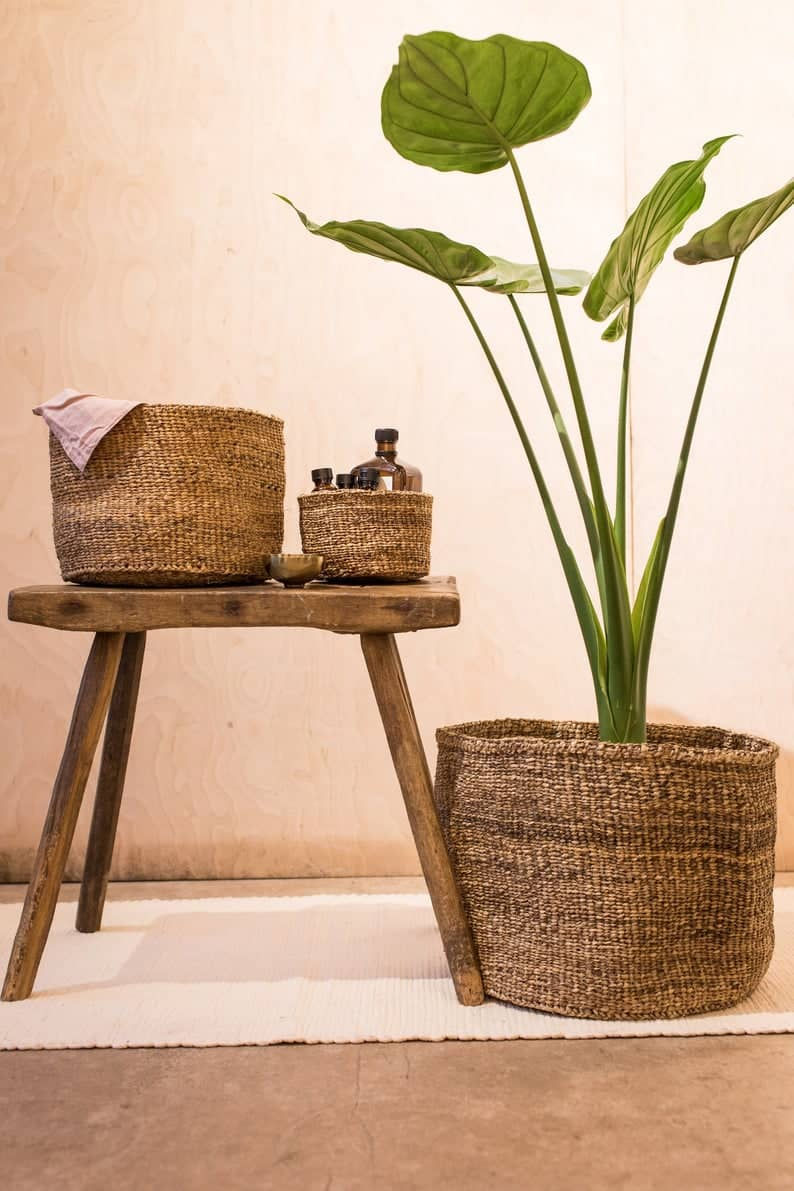 Handwoven basket made from banana tree fibres with monstera plant, next to tv stand. Click on the image to shop the basket on Etsy. 