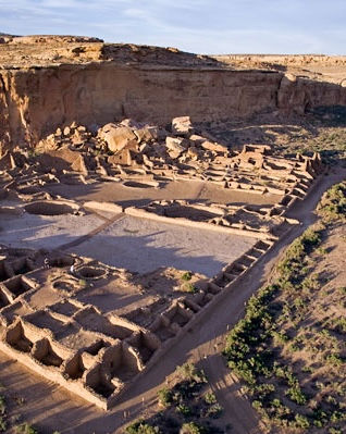 An aerial, wide-angle view of Pueblo Bonito was settled approximately between 850 CE and 1150, a massive D-shaped stone ruin in a desert canyon at Chaco Culture National Historical Park. As of 2026, the site is roughly 1,176 years old from the time construction first began. The ancestral Puebloan civilization flourished here for about 300 years before the complex was completely abandoned around 1200 CE