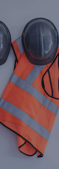 Hard hats and safety vests hanging on a wall