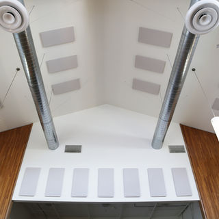 High ceiling with industrial ductwork and acoustic panels.