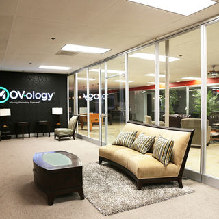 Modern office lobby with MOV-ology logo and sofa.